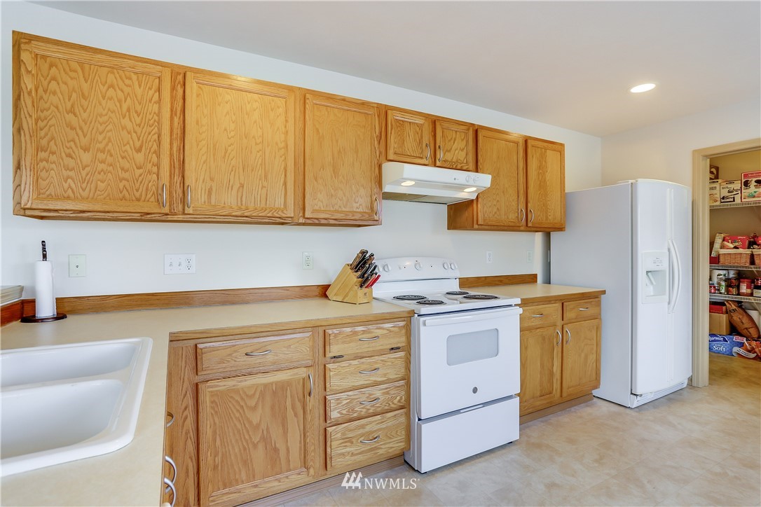2310 Southeast 3rd Street Renton, WA 98056 - Photo 12 of 30 a kitchen with stainless steel appliances granite countertop a stove a sink and a refrigerator