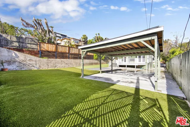 a view of a house with backyard and sitting area