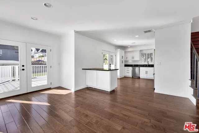 a view of a kitchen with wooden floor and a window