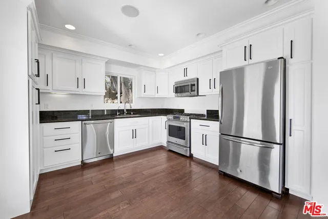 a kitchen with stainless steel appliances a refrigerator sink and microwave