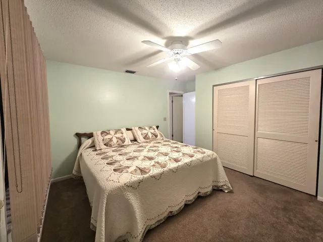 a bed sitting in a spacious bedroom next to a window