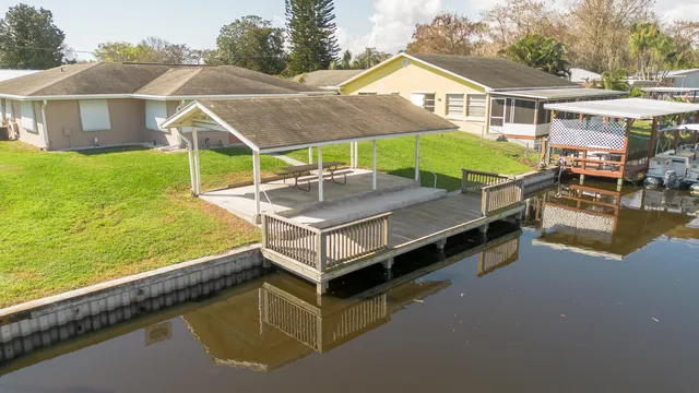a view of a house with pool and chairs