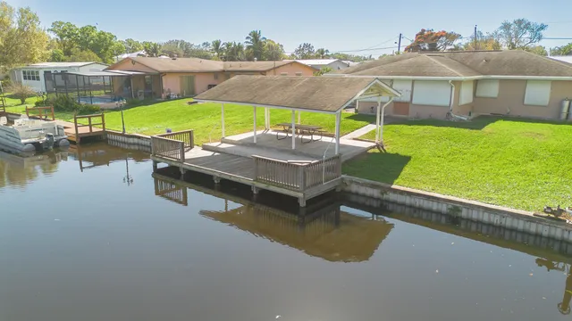 an aerial view of a house with swimming pool patio and lake view