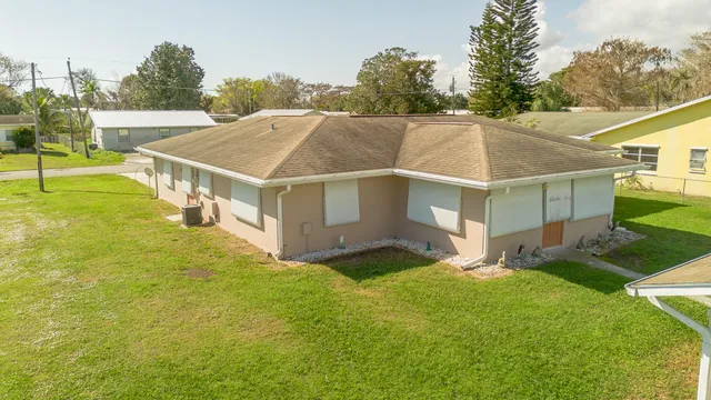 a view of an house with backyard and trees