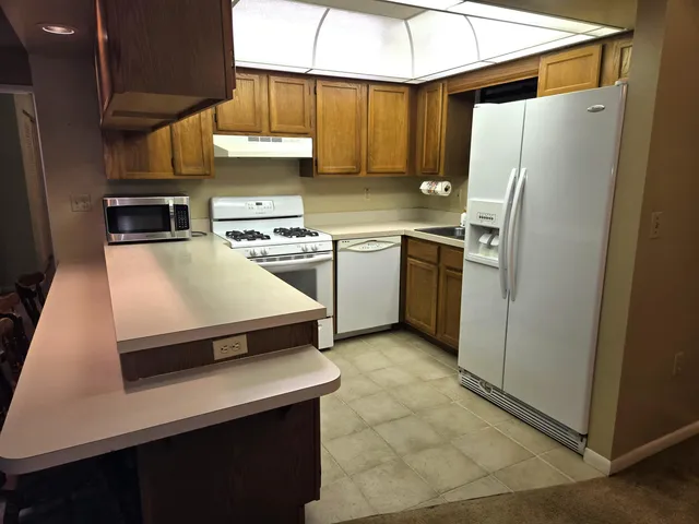 a kitchen with stainless steel appliances a refrigerator a stove a sink and a refrigerator