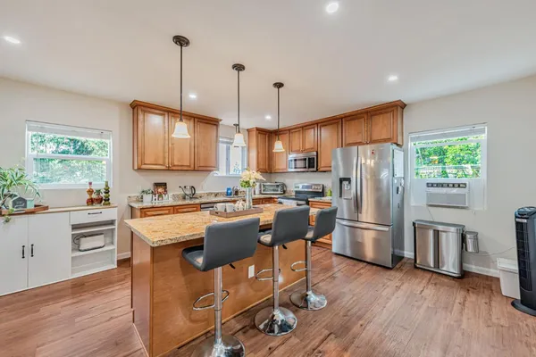 a kitchen with granite countertop a sink a counter top space appliances and cabinets