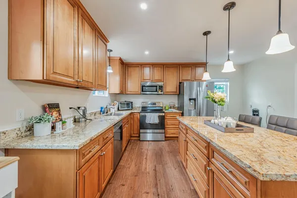 a kitchen with stainless steel appliances granite countertop sink stove and wooden floor