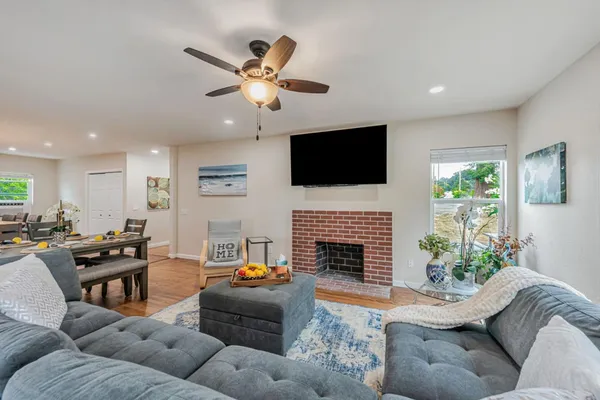 a living room with furniture a flat screen tv and a fireplace