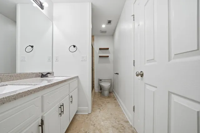 a spacious bathroom with a granite countertop sink and a mirror