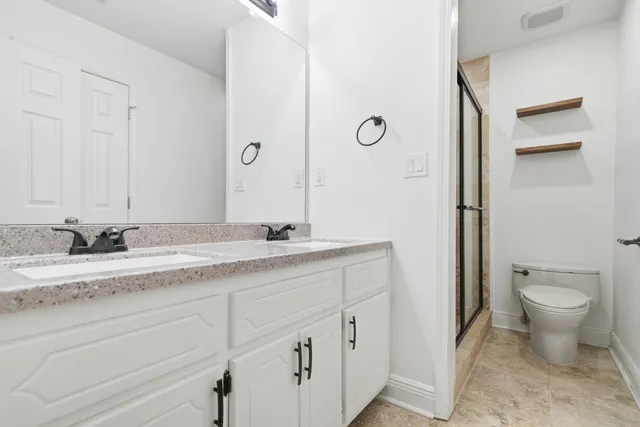 a bathroom with a granite countertop sink mirror and toilet