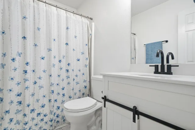 a bathroom with a sink a toilet and a mirror