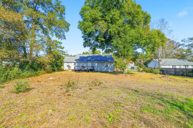 a view of a house with a patio and a yard