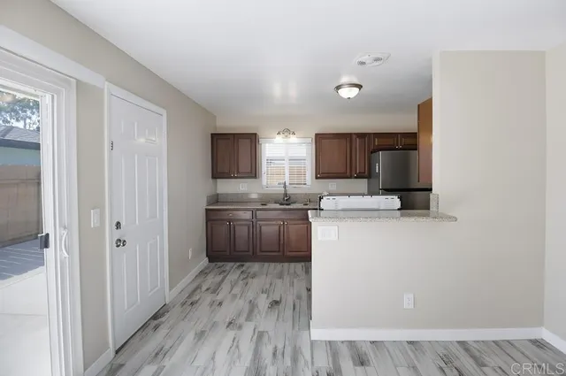 a kitchen with a refrigerator a sink and a stove top oven