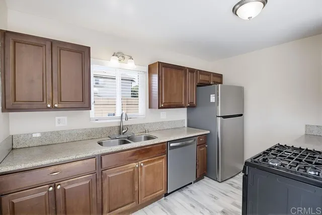 a kitchen with stainless steel appliances granite countertop a sink stove and cabinets