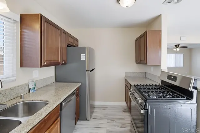a kitchen with stainless steel appliances granite countertop a sink stove and refrigerator