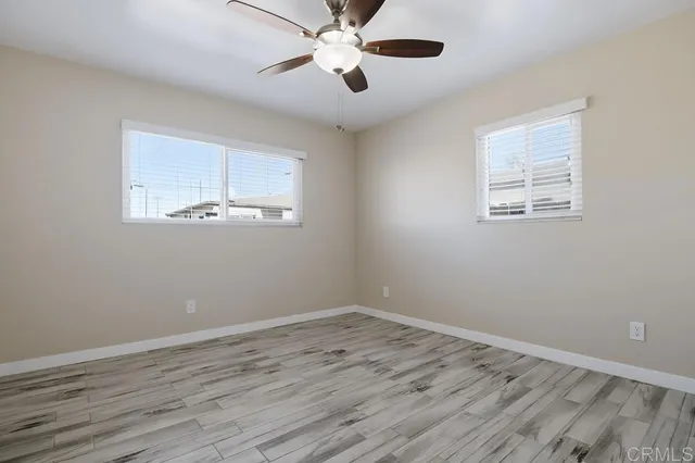 a view of empty room with wooden floor