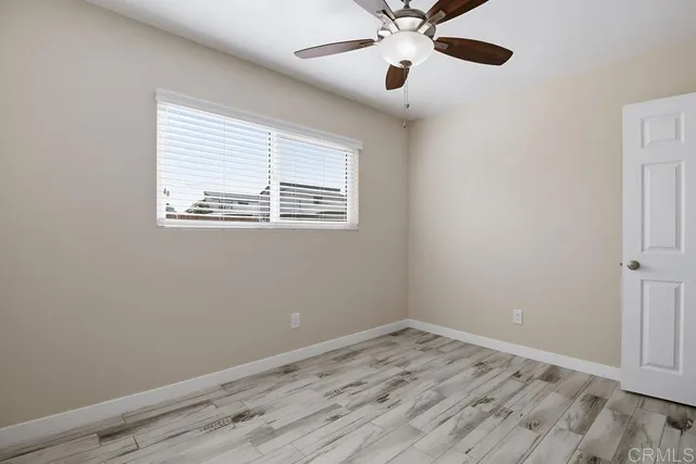 an empty room with a window and a fan