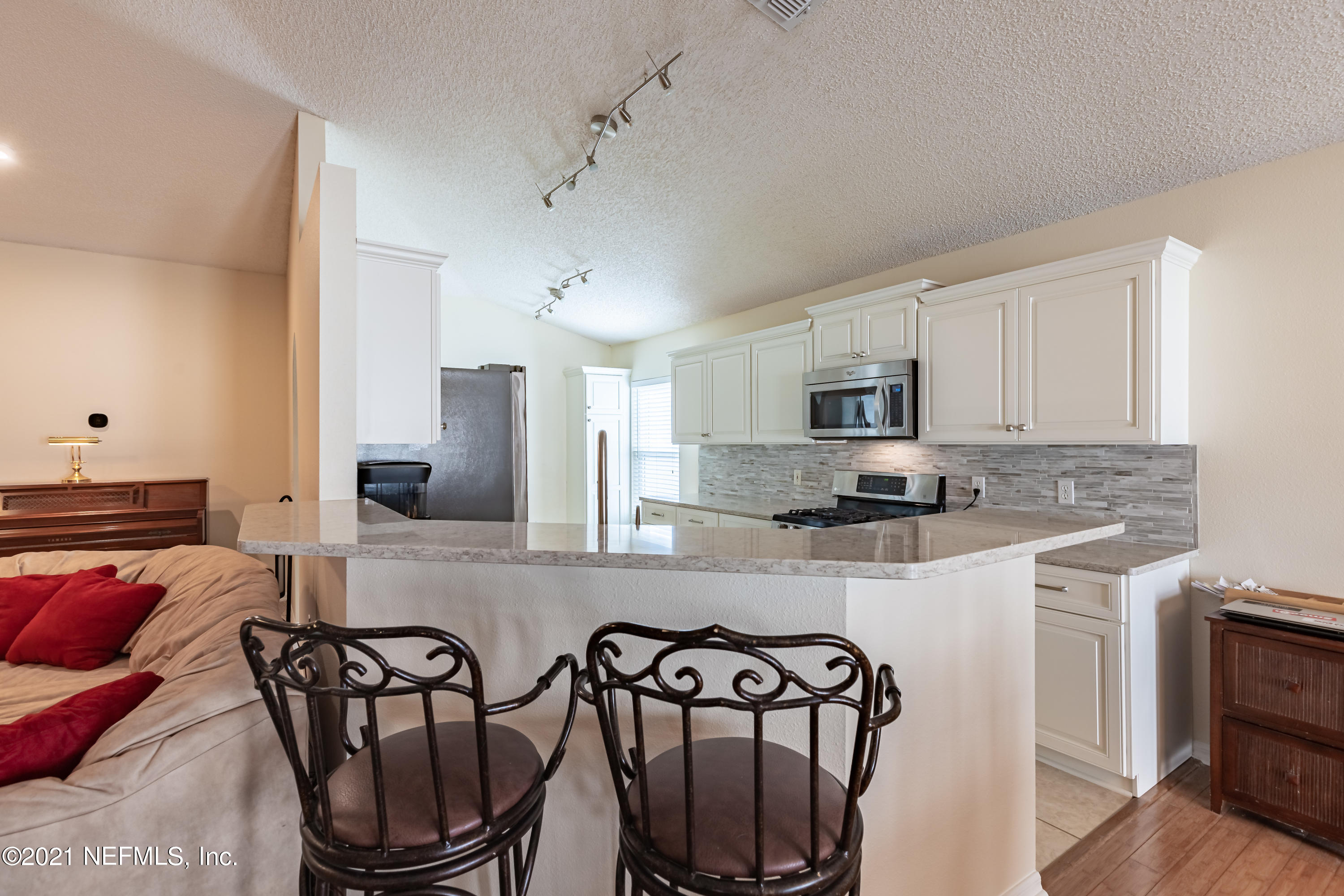 2602 Sunrise Ridge Lane Jacksonville, FL 32277 - Photo 11 of 35 a kitchen with stainless steel appliances a dining table chairs sink and cabinets