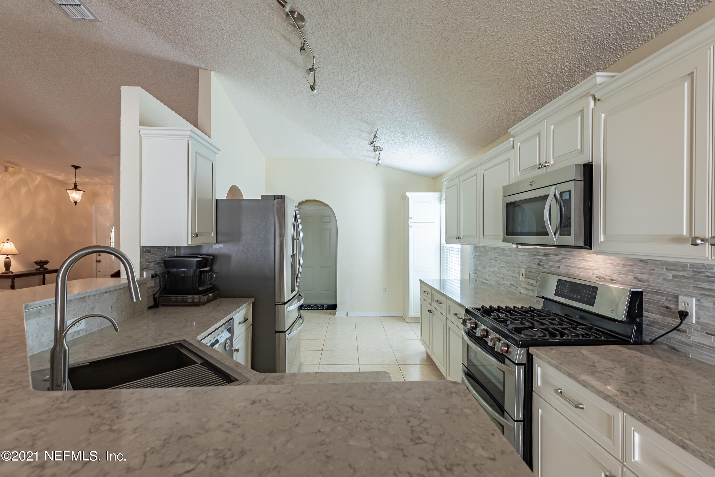 2602 Sunrise Ridge Lane Jacksonville, FL 32277 - Photo 12 of 35 a kitchen with stainless steel appliances granite countertop a stove a sink and a microwave