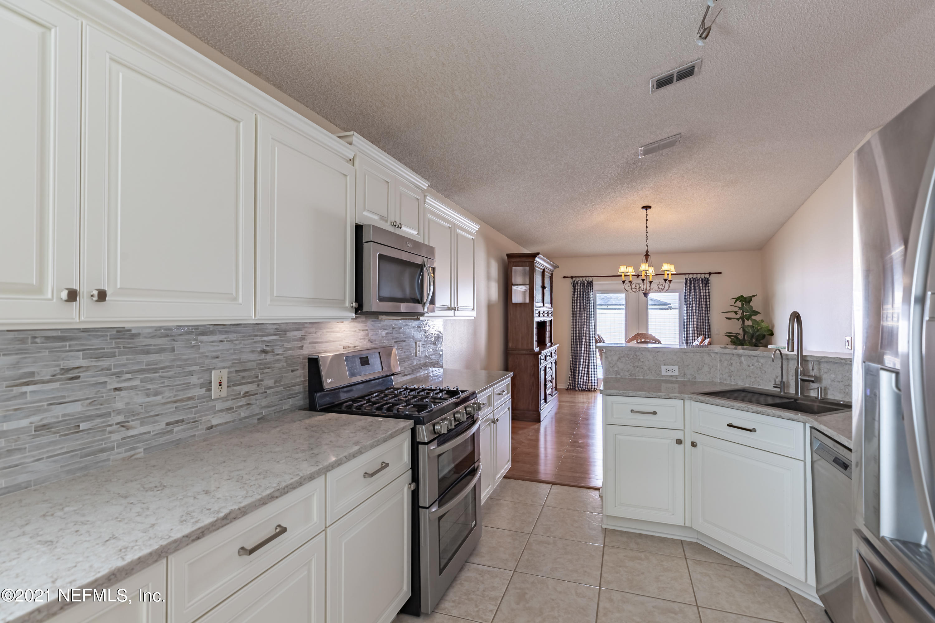 2602 Sunrise Ridge Lane Jacksonville, FL 32277 - Photo 14 of 35 a kitchen with granite countertop white cabinets stainless steel appliances and sink