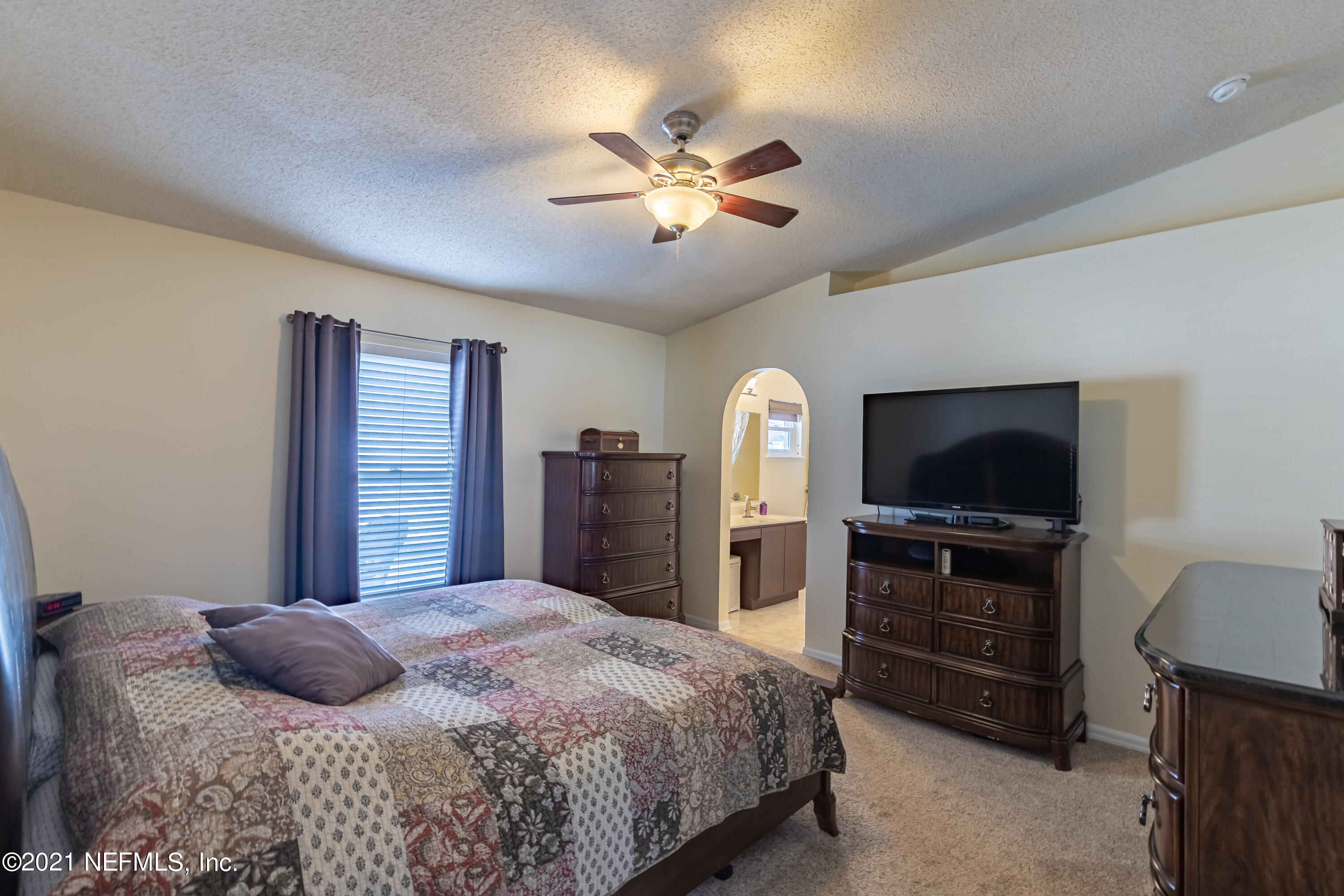 2602 Sunrise Ridge Lane Jacksonville, FL 32277 - Photo 22 of 35 a bedroom with a bed and a flat screen tv