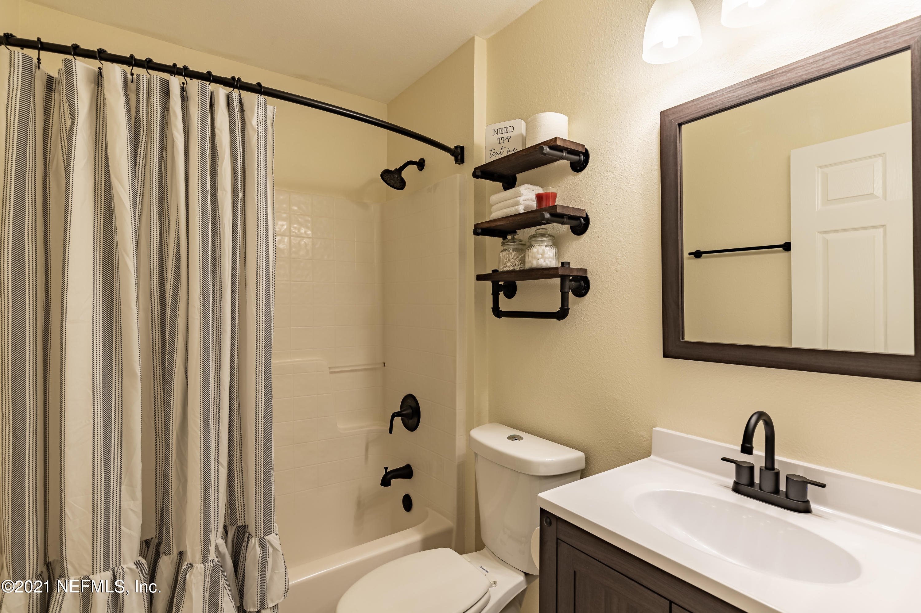 2602 Sunrise Ridge Lane Jacksonville, FL 32277 - Photo 25 of 35 a bathroom with a sink a toilet and shower curtain