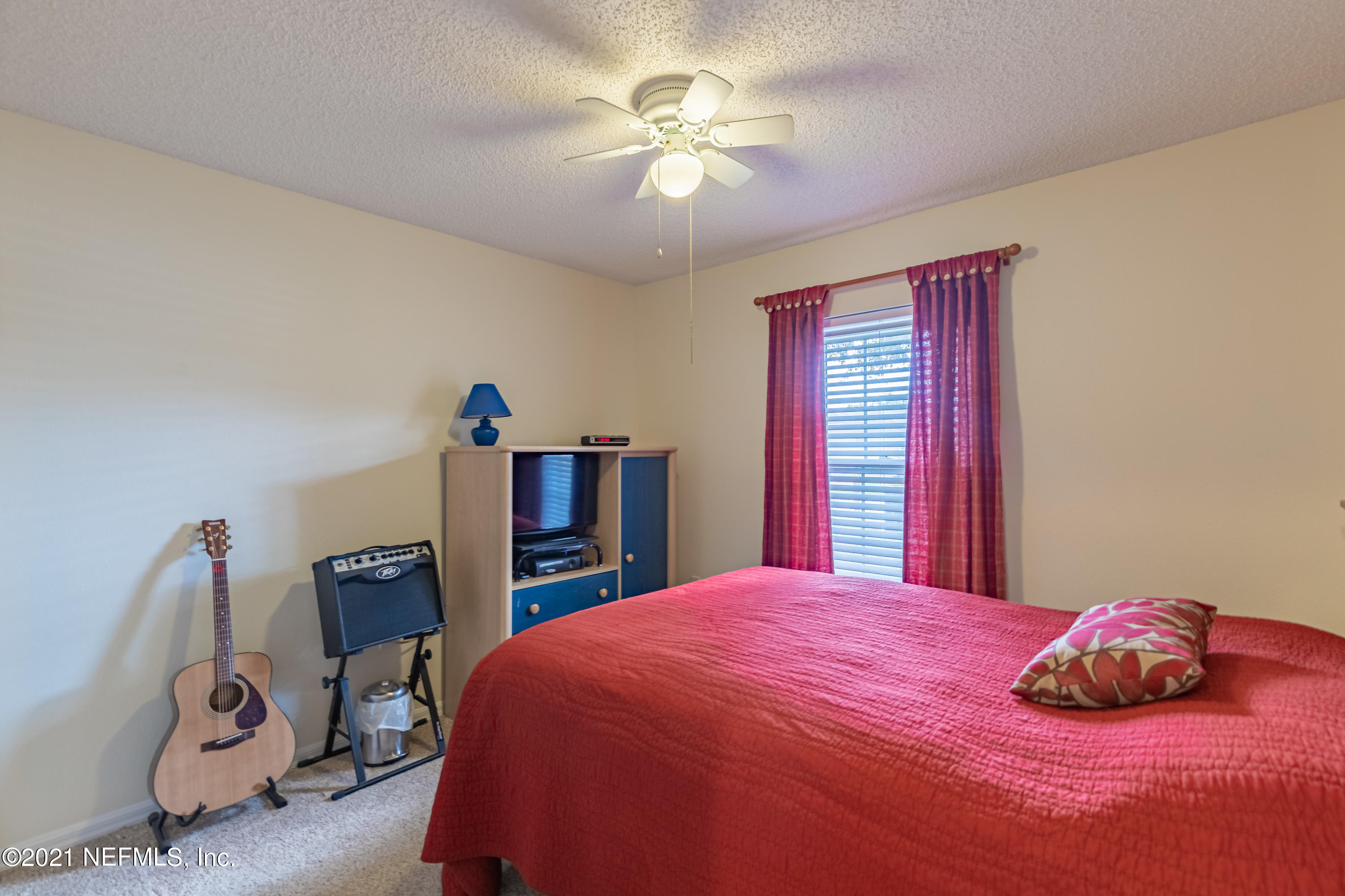 2602 Sunrise Ridge Lane Jacksonville, FL 32277 - Photo 26 of 35 a bedroom with a bed and a chandelier