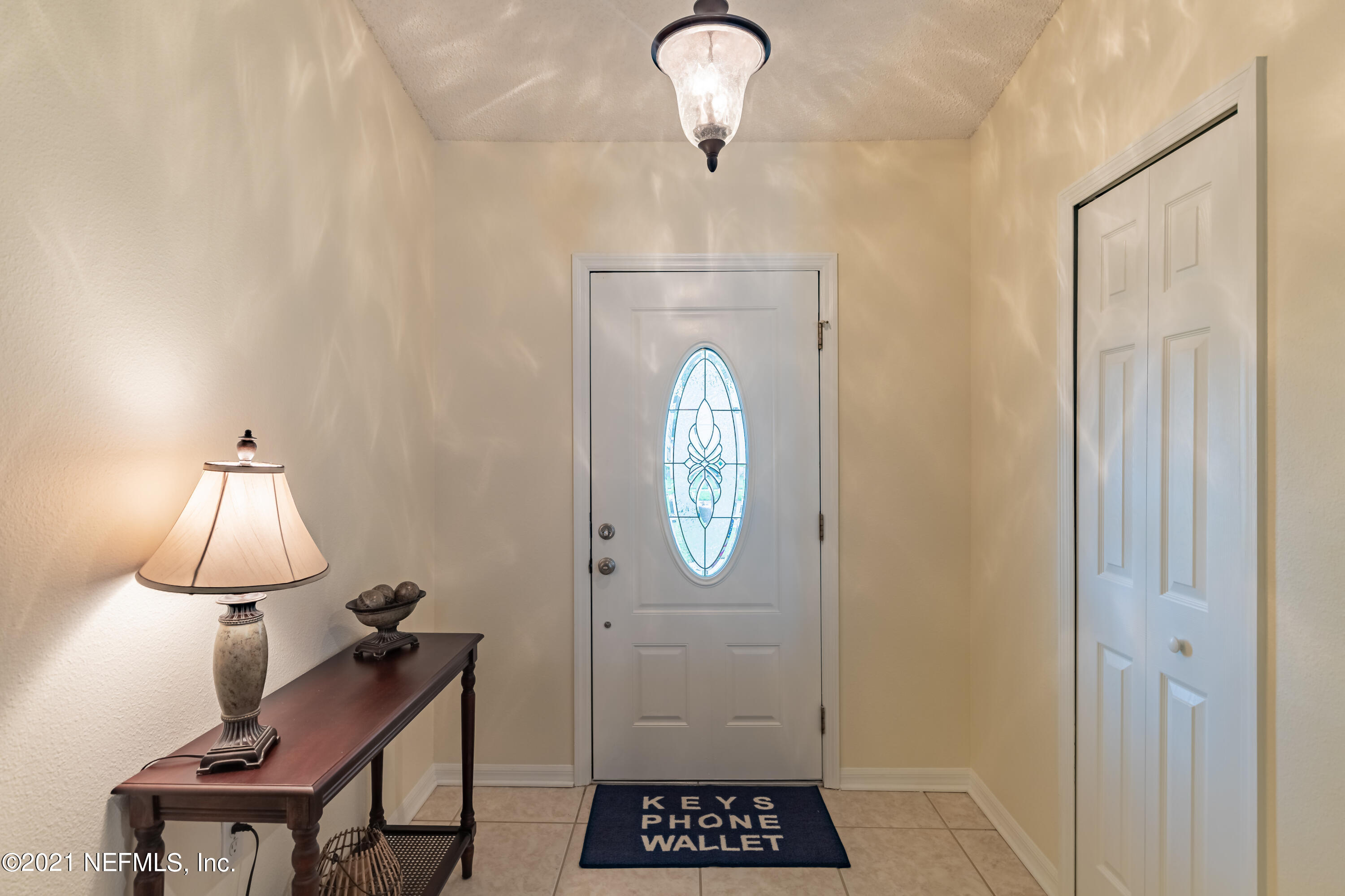 2602 Sunrise Ridge Lane Jacksonville, FL 32277 - Photo 5 of 35 a view of a hallway with entryway a chandelier fan and wooden floor