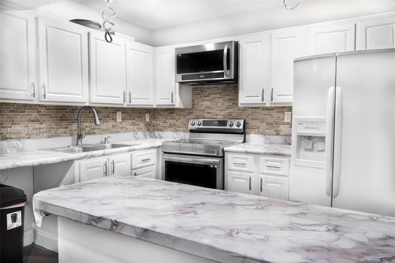 20300 Northeast 3rd Court, Unit 6 Miami, FL 33179 - Photo 7 of 14 a kitchen with a refrigerator stove and microwave