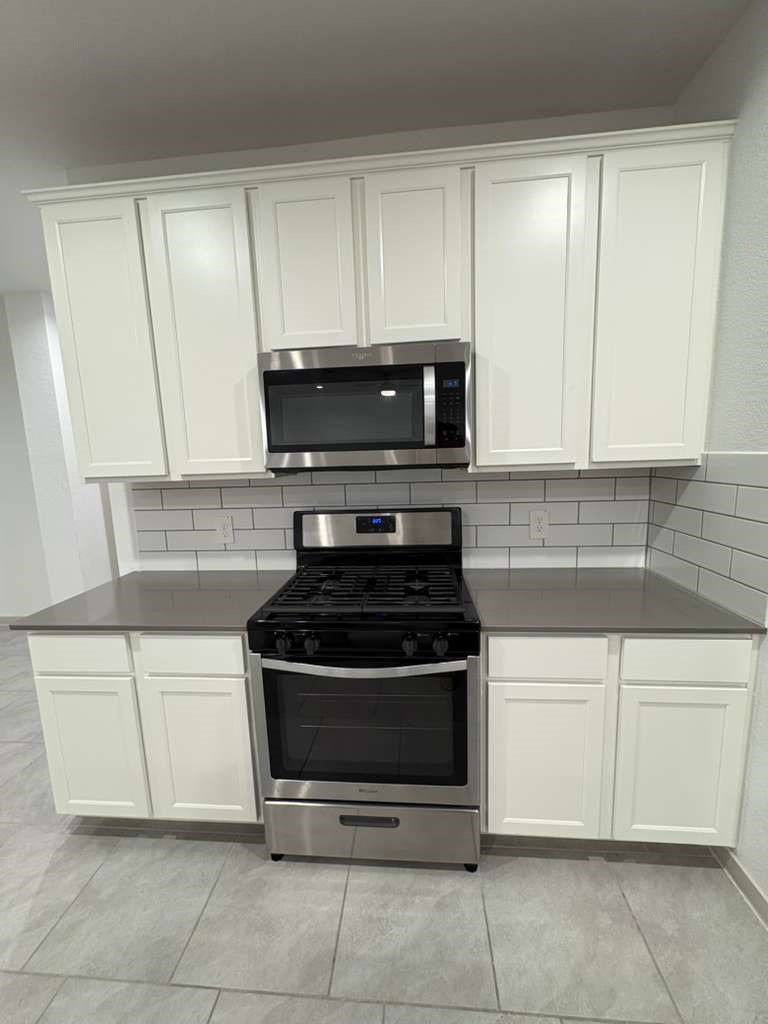 30018 Reagans Rnch Drive Fulshear, TX 77494 - Photo 11 of 30 a kitchen with white cabinets and appliances