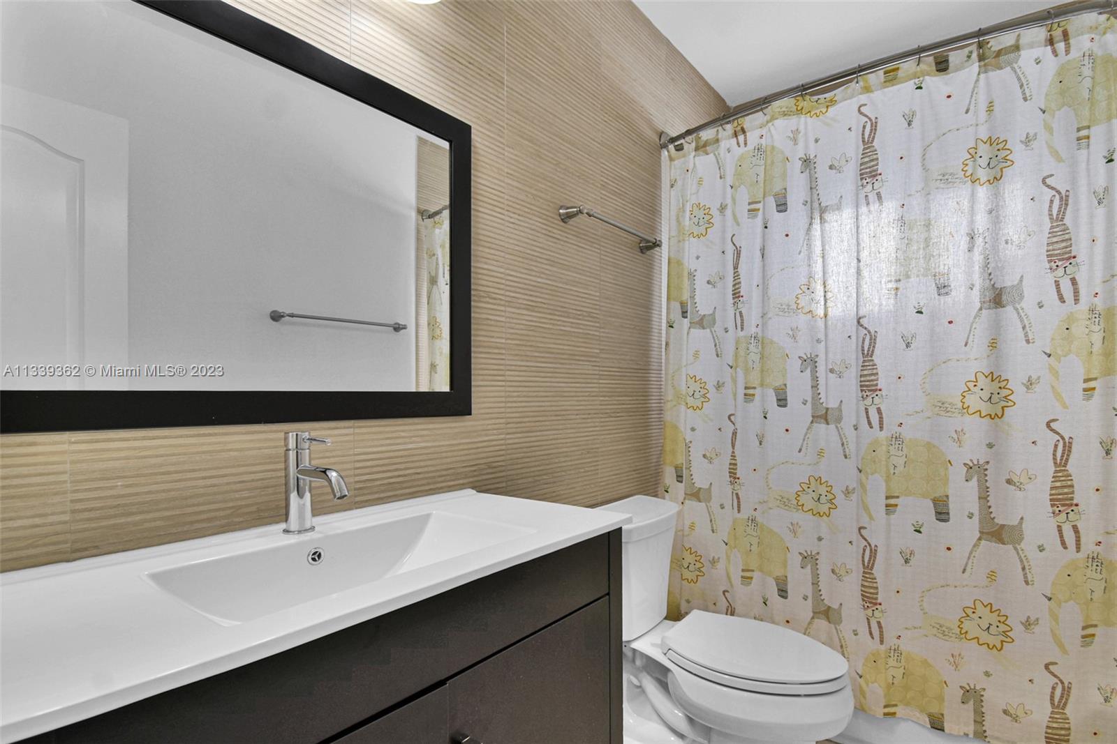 Dadeland Miami, FL 33173 - Photo 33 of 56 a bathroom with a double vanity sink toilet mirror and shower