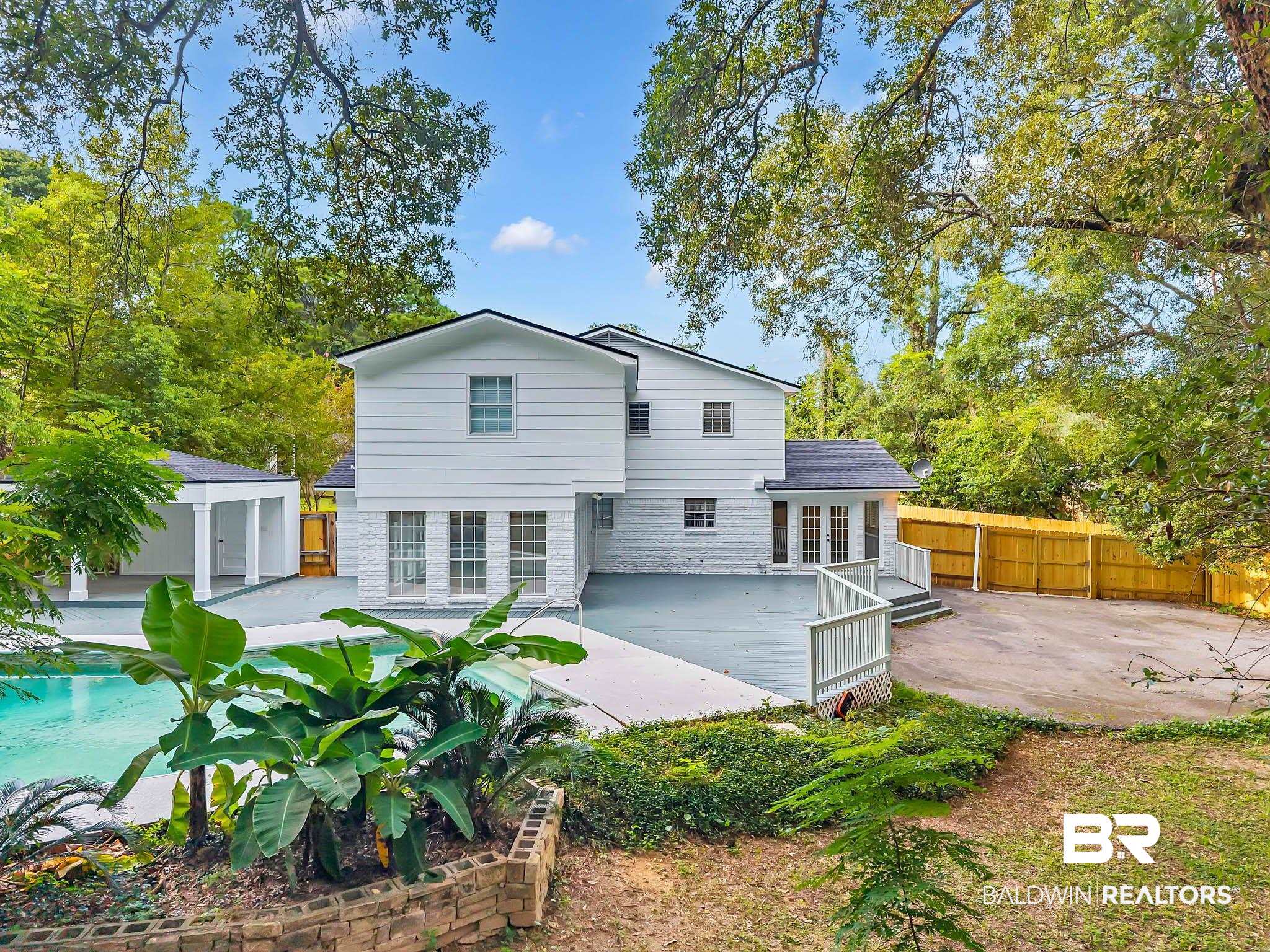 4705 Sherry Court Mobile, AL 36693 - Photo 63 of 100 Rear view of house featuring a patio area, an outdoor pool, brick siding, a wooden deck, and an outbuilding
