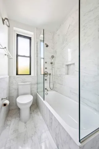 a bathroom with a granite countertop toilet a sink and bathtub