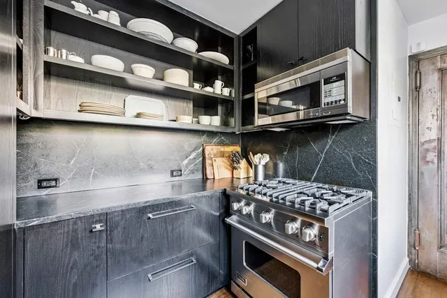 a kitchen with stainless steel appliances granite countertop a stove and a microwave
