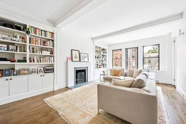 a living room with furniture a rug and a book shelf