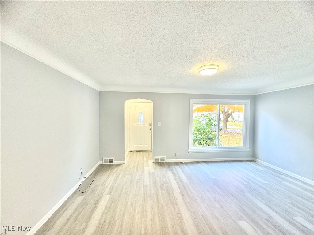 1215 Avondale Road Cleveland, OH 44121 - Photo 13 of 27 Empty room with light hardwood / wood-style flooring and a textured ceiling
