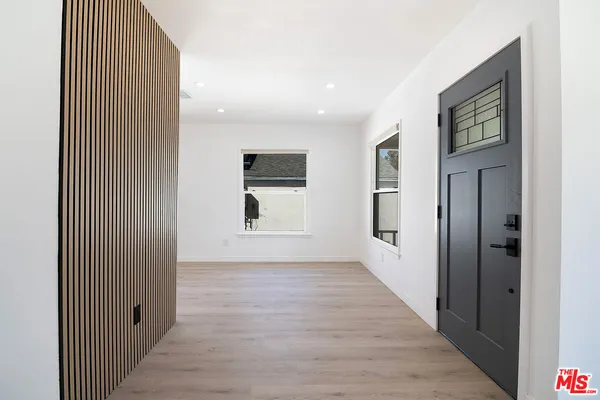 a view of a hallway with wooden floor and windows