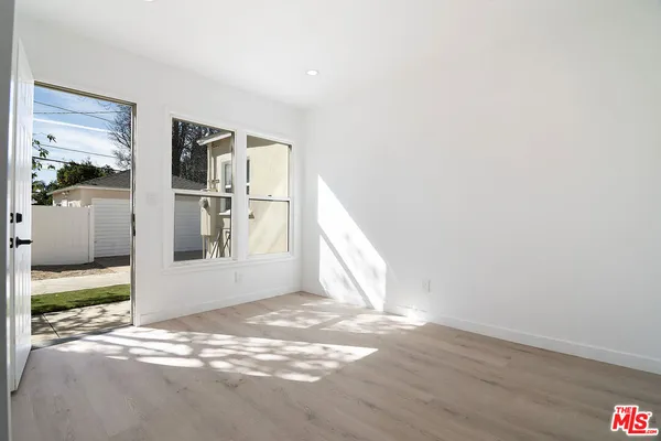 a view of a big room with wooden floor and windows