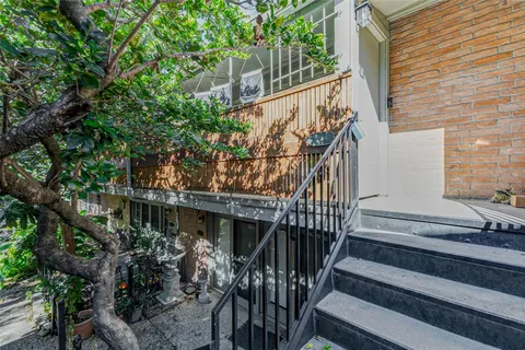 a view of house with wooden stairs and a tree