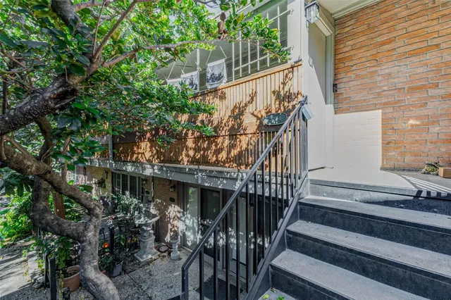 a view of house with wooden stairs and a tree