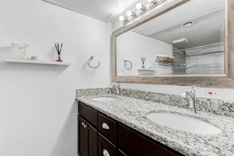 a bathroom with a granite countertop sink a mirror and vanity