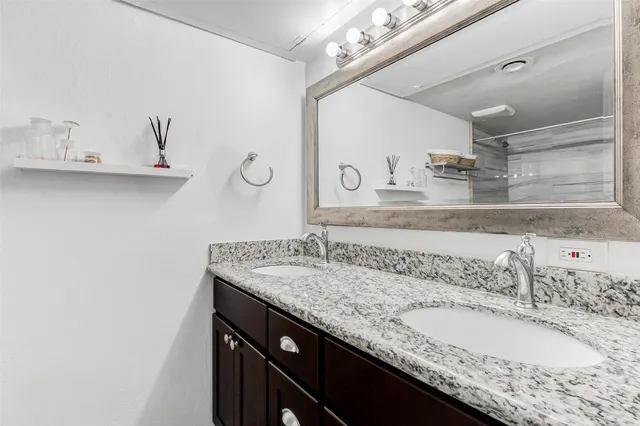 a bathroom with a granite countertop sink a mirror and vanity