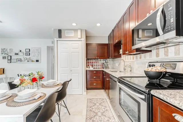 a kitchen with stainless steel appliances granite countertop a sink and cabinets