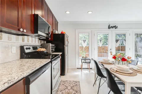 a kitchen with granite countertop kitchen island stainless steel appliances a sink stove and table