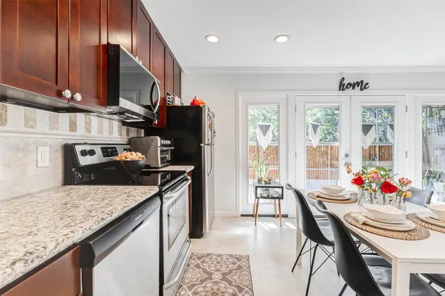 a kitchen with granite countertop kitchen island stainless steel appliances a sink stove and table