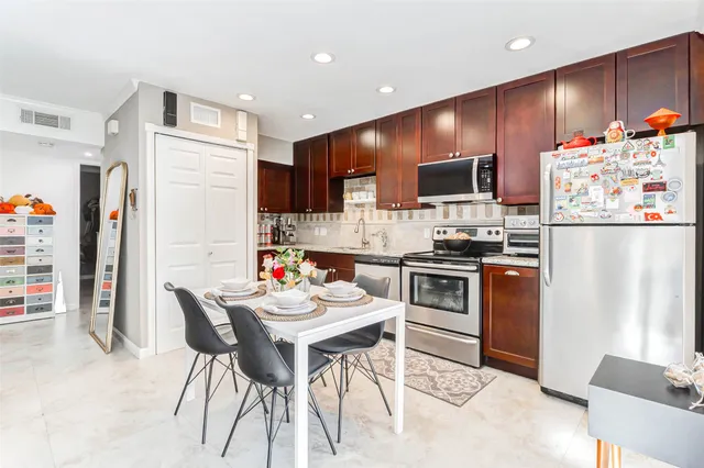 a kitchen with stainless steel appliances kitchen island granite countertop a refrigerator and a stove top oven
