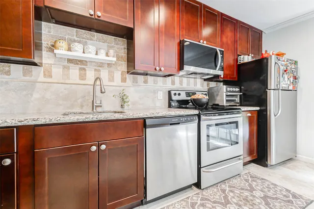 a kitchen with stainless steel appliances granite countertop a stove a sink and a microwave