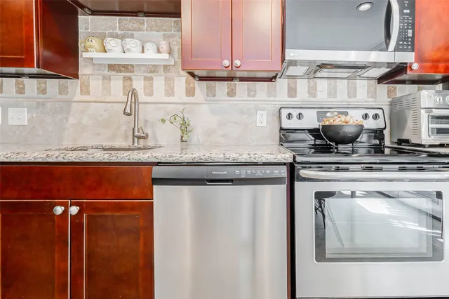 a kitchen with stainless steel appliances granite countertop a sink and a white cabinets