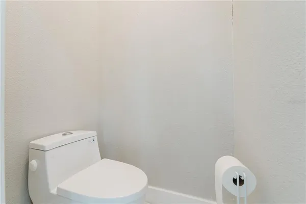 a white toilet sitting next to a white wall