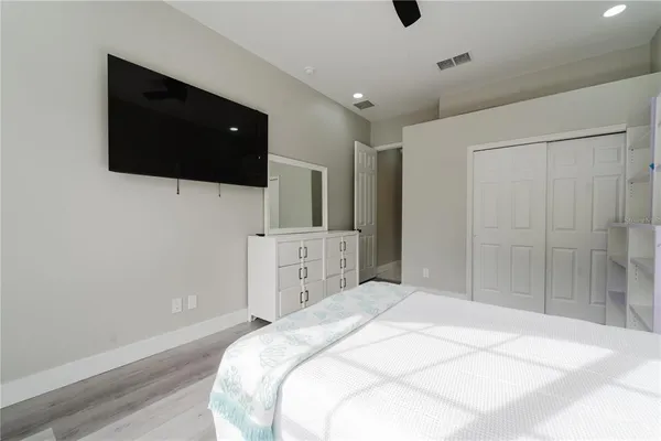 a spacious bedroom with a bed and a flat screen tv